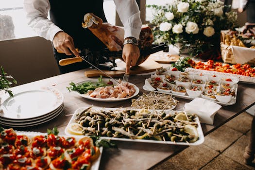 A chef slices meat in a beautifully arranged catering setup with diverse appetizing dishes.